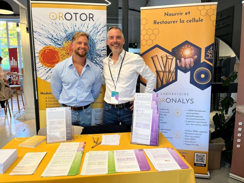 Deux membres de l'équipe Oronalys sur leur stand, en salon professionnel de praticiens
